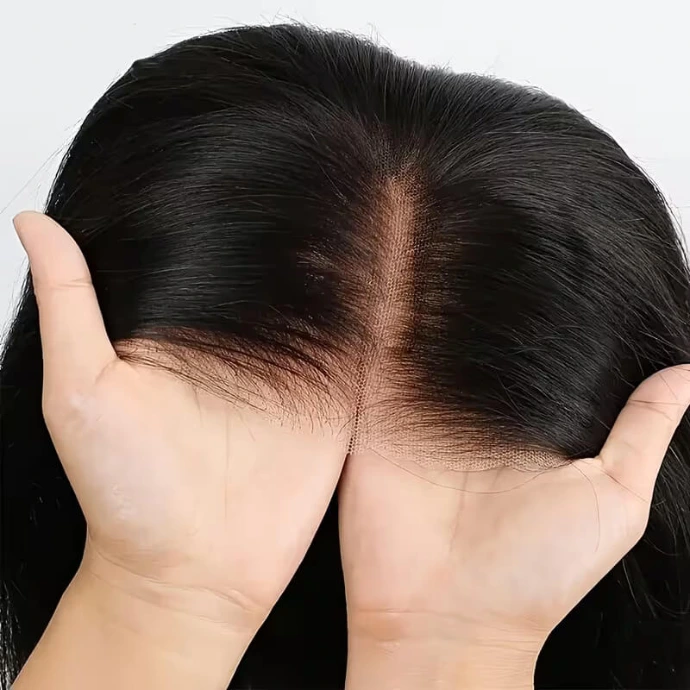 Close-up view of hands holding a black lace front wig, highlighting the realistic lace hairline detail for a natural-looking part